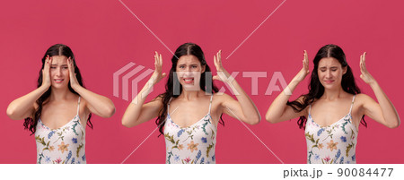 Beautiful woman in a white dress with floral print posing against a pink studio background. Beautiful woman in a white dress with floral print posing against a pink studio background. 90084477