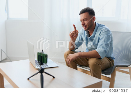 Joyful communicative attractive young blogger investor record video about NFT art cryptocurrency at phone camera using laptop. Copy space for ad. Remote Job, Technology And Career Profession Concept Joyful communicative attractive young blogger investor record video about NFT art cryptocurrency at phone camera using laptop. Copy space for ad. Remote Job, Technology And Career Profession Concept 90084557