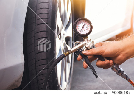 A auto mechanic inflates a tire with an air tire inflating gun 90086107