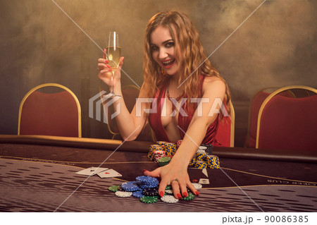 Charming woman with a beautiful hairstyle and perfect make-up is playing poker. Casino. Charming woman with a beautiful hairstyle and perfect make-up is playing poker. Casino. 90086385