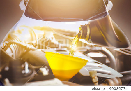 The Engine oil pouring into the car engine with a sunlight and automobile double exposure 90086774