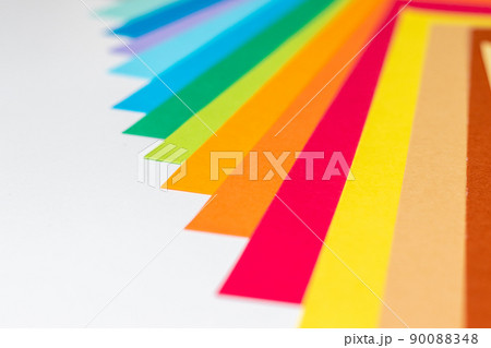 テーブルの上に重ねて並べられたカラフルな紙 テーブルの上に重ねて並べられたカラフルな紙 90088348