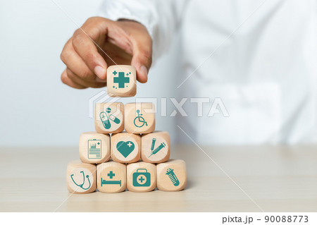 Doctor holding wooden cube blocks stacking with medical icons. treatment and medicine symbol signs. 90088773