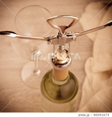 Wine bottle with corkscrew on wooden background Wine bottle with corkscrew on wooden background 90091074