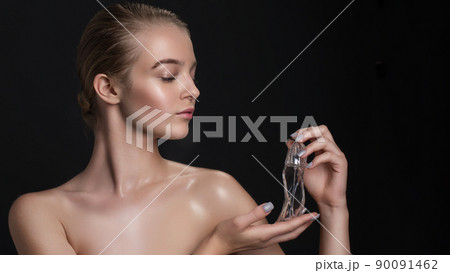 Young beautiful woman with a bottle of perfume. Model with healthy skin, close up portrait. Cosmetology, beauty and spa Young beautiful woman with a bottle of perfume. Model with healthy skin, close up portrait. Cosmetology, beauty and spa 90091462