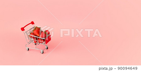 Fresh red strawberry in shopping card on pink background. Online shopping and Valentines Day minimalistic concept. Black Fridays sales banner. Healthy, organic, vegan food Fresh red strawberry in shopping card on pink background. Online shopping and Valentines Day minimalistic concept. Black Fridays sales banner. Healthy, organic, vegan food 90094649