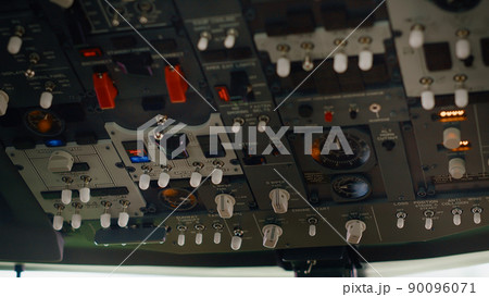 Aircraft dashboard command in empty plane cockpit used to fly with engine throttle and power speed. Control panel buttons and lever fot navigation with radar compass and windscreen. Close up. 90096071