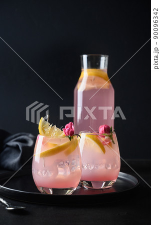 Cocktails with pink rose gin and lemon on black background. Cocktails with pink rose gin and lemon on black background. 90096342