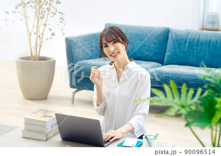 リビングでパソコンを操作するテレワーク中のビジネスウーマン リビングでパソコンを操作するテレワーク中のビジネスウーマン 90096514