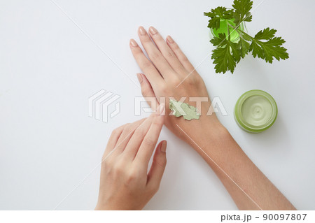 Top view of mugwort on petri dish cosmetic jar with hand model in white background 90097807