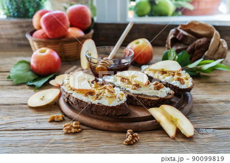 Bread slices with cottage cheese, honey, apples and nuts Bread slices with cottage cheese, honey, apples and nuts 90099819