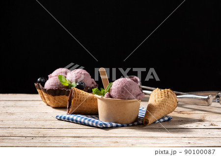 Blueberry ice cream scoops with waffle on wooden table Blueberry ice cream scoops with waffle on wooden table 90100087