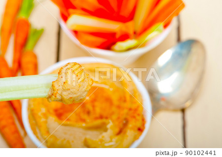 fresh hummus dip with raw carrot and celery 90102441