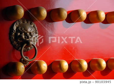 Detail of a traditional Chinese door at the Xiaoling Mausoleum of Ming Dynasty in Nanjing, Jiangsu Province, China. Red door with lion handle. Detail of a traditional Chinese door at the Xiaoling Mausoleum of Ming Dynasty in Nanjing, Jiangsu Province, China. Red door with lion handle. 90103945