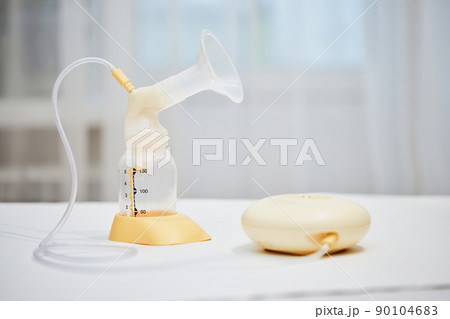 Breast pump with empty baby bottle on table 90104683