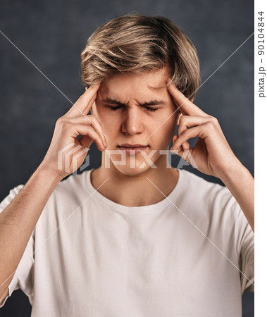 young handsome guy thinking on gray background. 90104844