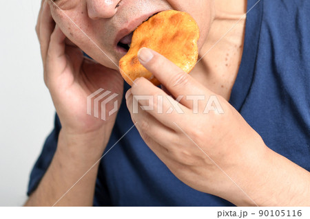 辛い表情で煎餅を食べる高齢者の男性 辛い表情で煎餅を食べる高齢者の男性 90105116