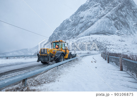 Snow ploughing truck cleaning snow on the road in suburban during heavy snowstorm 90106875