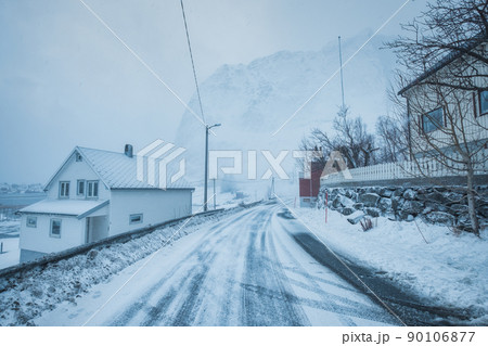 Fishing village with snow mountain on the road in snow storm on winter at Lofoten Islands 90106877