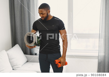 Man in a isolations. Guy training in a room. Man with dumbbells. Man in a isolations. Guy training in a room. Man with dumbbells. 90108084