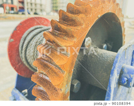 metal, rusty and old reel with a wound electric cable. construction site. orange rust from water on a metal circle. cable for electricity supply metal, rusty and old reel with a wound electric cable. construction site. orange rust from water on a metal circle. cable for electricity supply 90108394