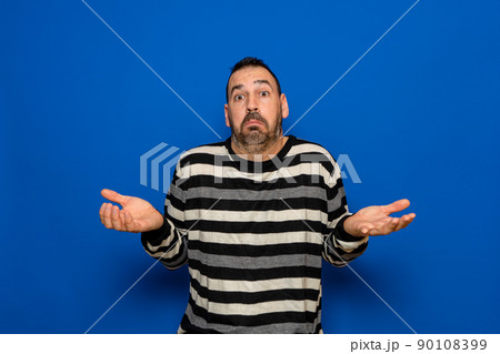 Latin man with beard doubt expression, concept of confusion and amazement, uncertain future isolated on blue background Latin man with beard doubt expression, concept of confusion and amazement, uncertain future isolated on blue background 90108399