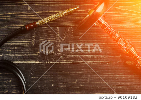 Dismantled parts of hookah on wooden background. Sun flare Dismantled parts of hookah on wooden background. Sun flare 90109182