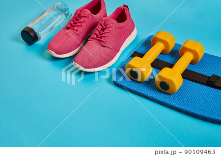 Healthy concept, diet plan with sport shoes and bottle of water and dumbbells on blue background, healthy food and exercise concept 90109463