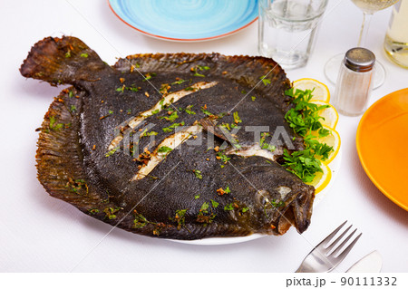 Baked flounder with parsley and lemon. Mediterranean cuisine closeup 90111332