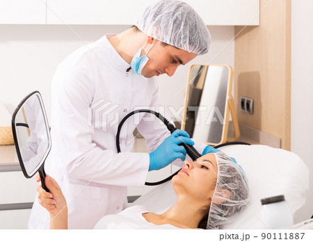 Beautician performing female face skin rf lifting Beautician performing female face skin rf lifting 90111887