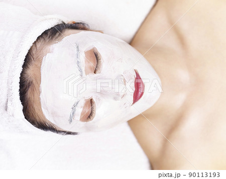 beautiful young asian woman receiving a facial skincare treatment 90113193