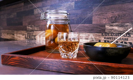 グラスに注いだ手作り梅酒と梅酒漬けの梅のシックな背景画像 グラスに注いだ手作り梅酒と梅酒漬けの梅のシックな背景画像 90114123