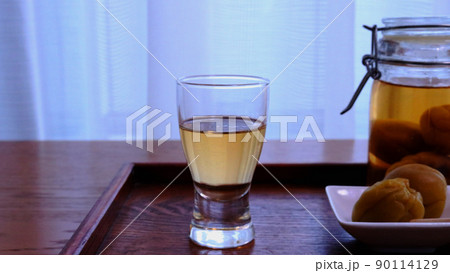 グラスに注いだ手作り梅酒とよく漬かった梅　明るい背景 90114129