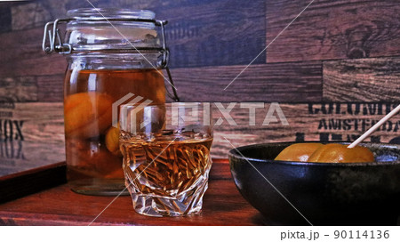 カットグラスにそそいだ梅酒と漬かった梅で家飲み 90114136