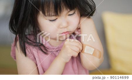 怪我をした腕の絆創膏を気にする4歳の子供（育児・子育て） 90114699