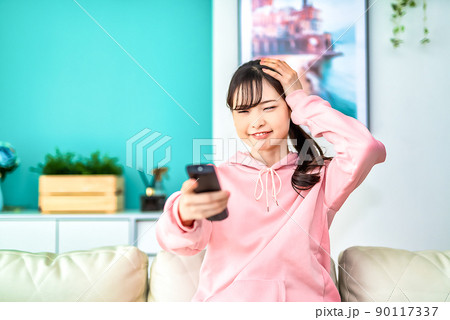 テレビを見る若い女性 驚く テレビを見る若い女性 驚く 90117337