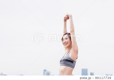 スポーツウェアで深呼吸をする若い女性 90117739