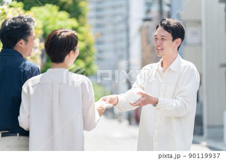 街中でポケットティッシュ配りのアルバイトをする男性 街中でポケットティッシュ配りのアルバイトをする男性 90119937