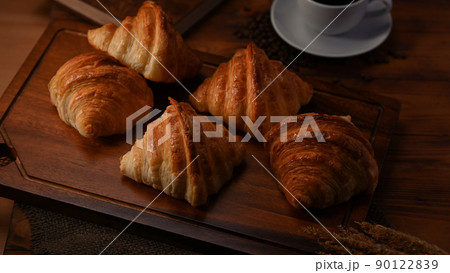 Delicious fresh croissants and coffee cup on wooden board 90122839