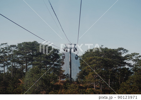 Circulating cable car between Dalat bus station and Robin Hill Truc Lam Vietnam. Intermediate support tower. Picturesque landscape view. Pine forest tree tops, clear sky. Evening mood. Collection Circulating cable car between Dalat bus station and Robin Hill Truc Lam Vietnam. Intermediate support tower. Picturesque landscape view. Pine forest tree tops, clear sky. Evening mood. Collection 90123971