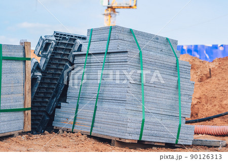 Industrial building cement pressed materials. Concrete block cement brick. Finished products on pallets compactly stacked wooden frame placed on construction site house, rope tape packed open air sky Industrial building cement pressed materials. Concrete block cement brick. Finished products on pallets compactly stacked wooden frame placed on construction site house, rope tape packed open air sky 90126313