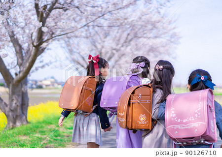 ランドセルを背負って楽しく登校する小学生の女の子たち 90126710