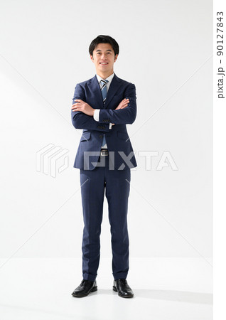 スーツ姿で腕を組み笑顔のビジネスマン 90127843