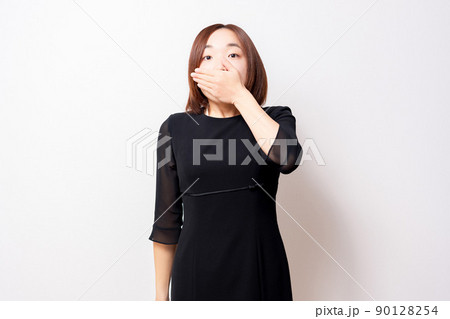 口を手で隠す喪服を着ている女性 90128254
