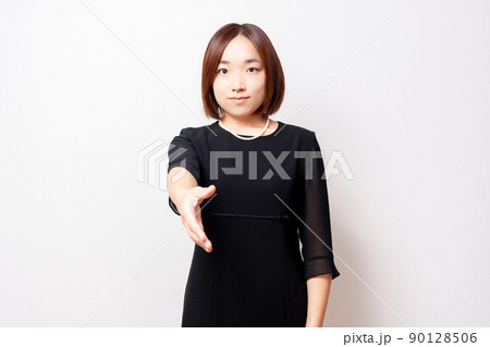 手を差し伸べる喪服を着ている女性 90128506