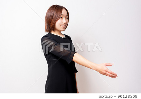 手を差し伸べる喪服を着ている女性 90128509