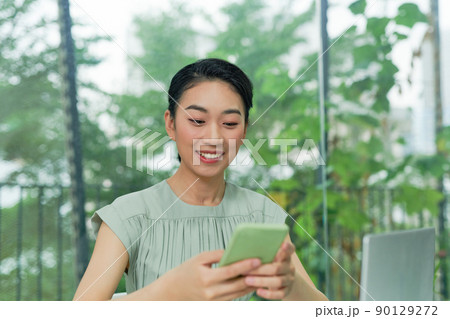 happy businesswoman or secretary messaging on smartphone at office 90129272