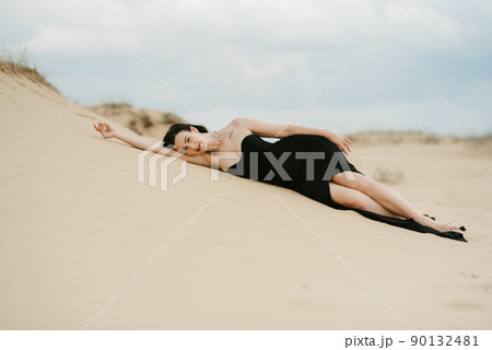girl in a black long dress in a sandy desert 90132481