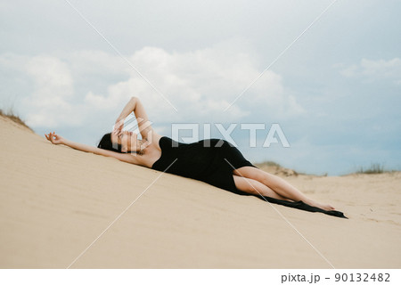girl in a black long dress in a sandy desert 90132482