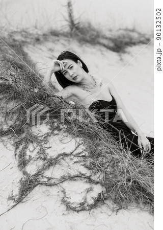girl in a black long dress in a sandy desert girl in a black long dress in a sandy desert 90132502